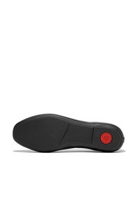 Schwarze Schuhsohle mit strukturiertem Grip, runder Form und einem auffälligen roten, runden Logo. Genähte Details entlang des Randes.