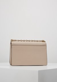 Borsa in ecopelle beige dal design strutturato, con tracolla in catena dorata, superficie liscia e un'estetica pulita e minimalista.