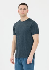 Mörkblå kortärmad t-shirt i ett mjukt, texturerat tyg med rundad halsringning och subtilt varumärke på bröstet, tillsammans med blå shorts.