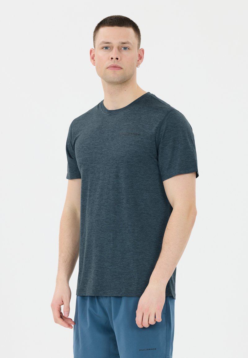 Mörkblå kortärmad t-shirt i ett mjukt, texturerat tyg med rundad halsringning och subtilt varumärke på bröstet, tillsammans med blå shorts.