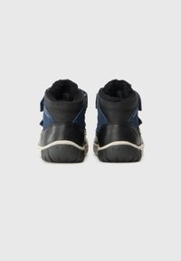 Zwarte en marineblauwe hoge schoenen met een klittenbandsluiting, een gevoerde kraag en een gestructureerde rubberen zool met een logo op de achterkant.