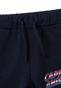 Navy blue sweatpants featuring an elastic waistband with drawstring, and a colorful "Captain America" graphic on the left thigh.