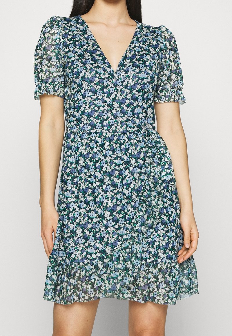Květinové šaty s hlubokým výstřihem do V, krátkými nabíranými rukávy a rozšířeným spodním lemováním. Vyrobené z lehkého materiálu s modrými a zelenými květinovými vzory.