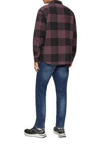 Chemise en flanelle à manches longues à carreaux noire et bordeaux, associée à un jean en denim bleu et des chaussures de sport noires, vue de dos.