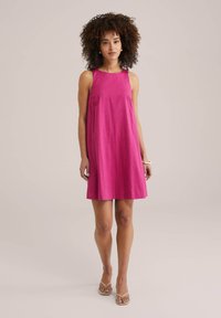 Fuchsia ärmlös klänning med rak silhuett, tillverkad av lätt tyg. Har en rund halsringning och når ovanför knäna.