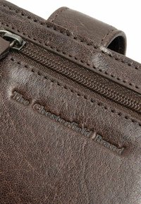 Borsa in pelle marrone con finitura testurizzata, dotata di chiusura con zip e logo impresso "The Chesterfield Brand".