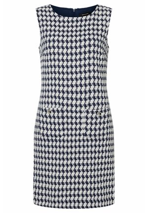 Robe sans manches en motif pied-de-poule bleu marine et blanc. Présente un col rond, une fermeture éclair au dos et deux poches avant avec des accents métalliques.
