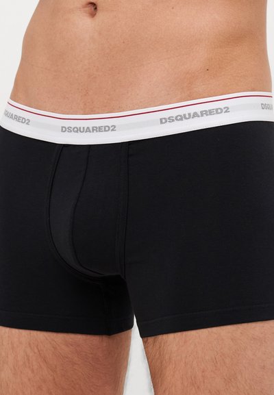 Schwarze boxer Shorts aus Baumwolle mit tailliertem Design. Verfügt über einen weißen Bund mit roten Akzenten und einem bedruckten Logo. Sanfte Textur.