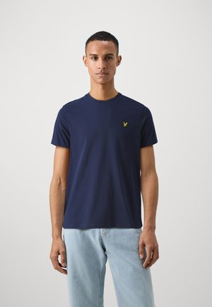 Camiseta de algodón azul marino de mangas cortas y cuello redondo, con un pequeño logo amarillo bordado en el lado izquierdo del pecho.