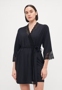 Black satin robe with lace accents on sleeves and neckline, featuring a wrap design and tie waist. Smooth texture and knee-length cut.