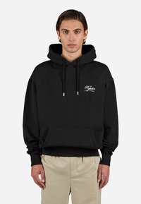 Black hoodie made of cotton with a kangaroo pocket, drawstring hood, and white logo on the chest. Features ribbed cuffs and hem.