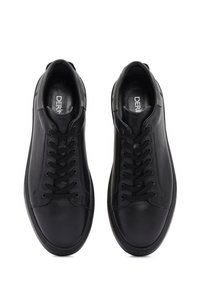 Un paio di sneakers in pelle nera con lacci, con punta tonda, viste dall'alto, su uno sfondo bianco.