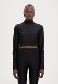 Black, long-sleeve crop top with a high neckline, featuring an elastic band with embossed "JUST CAVALLI" text. Smooth, fitted material.