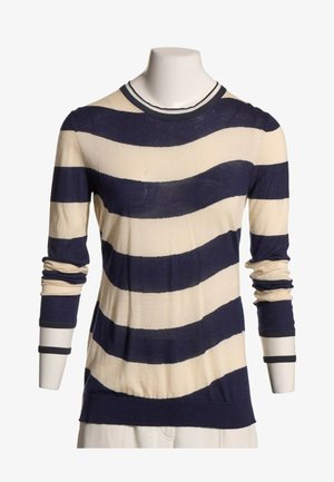Jersey de manga larga con amplias y irregulares franjas horizontales en azul marino y crema, exhibido sobre un torso de maniquí blanco.
