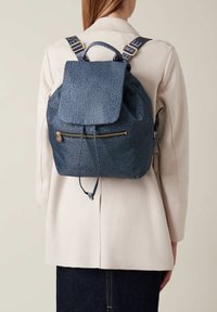 Dunkelblauer strukturierter Rucksack mit Klappenverschluss, vorderer Reißverschlusstasche und verstellbaren Trägern mit Logodetails.
