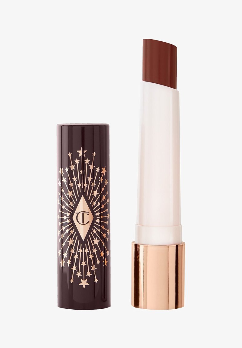 Dark brown lipstick with a white and rose gold tube, beside a dark brown cap decorated with gold stars and a diamond-shaped logo.