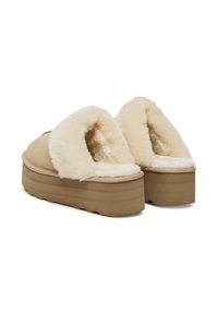 Světlé platformové pantofle s měkkou krémovou imitací jemného ovčího rouna. Textilní svršek, zaoblený design, silná podrážka a polstrovaný opening pro pohodlí.