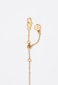 Cadena de oro con un cierre de langosta y un sujetador redondo, que presenta un pequeño rhinestone claro. La cadena es delicada e interconectada.