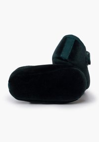 Botitas negras suaves para bebé con suelas redondeadas y correas de Velcro, mostradas desde la parte inferior y lateral sobre un fondo blanco.