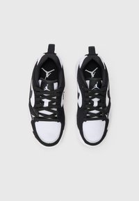 Crne i bijele atletske tenisice od mrežastog i antilop materijala, s okruglim vezicama, trakama za povlačenje i Jumpman logotipom na jeziku i bočnim stranama.