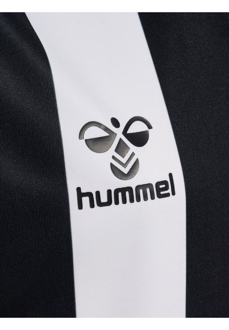 Svart och vit sporttröje tyg med ett vertikalt randigt mönster och en framträdande Hummel-logotyp i svart. Slät textur.