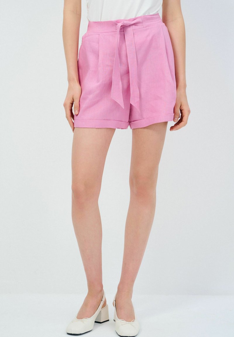 Rosa linneshorts med ett knytbälte, med framveck och uppvikta fållar. Slät yta och avslappnad passform, passar bra för varma väder.