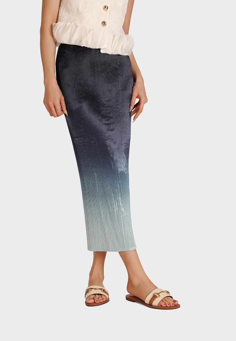 Gonna midi leggera a righe verticali in blu scuro che sfuma in teal chiaro all'orlo. Abbinata a sandali slip-on beige con una cintura decorativa.