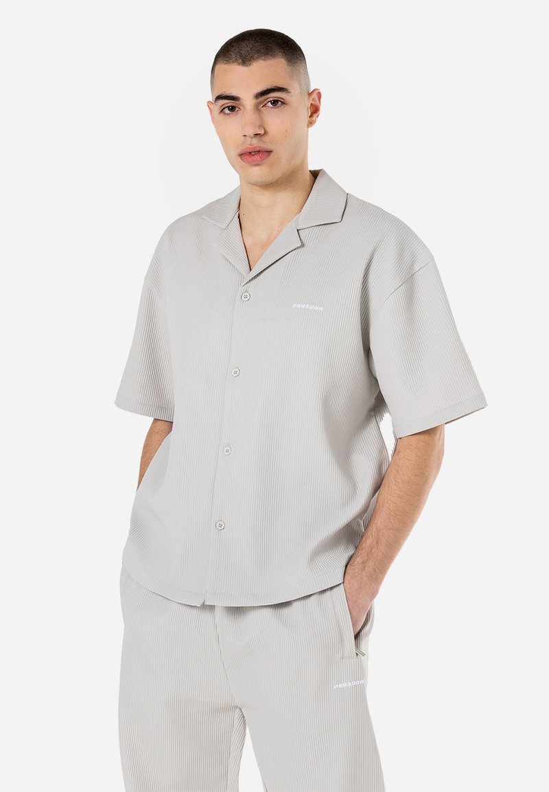Camisa de botão de manga curta cinza claro com textura em reque. Possui colarinho com recorte, bolso frontal e logótipo discreto no peito.