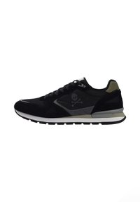 Zapatilla deportiva negra con parte superior de ante y malla, acentos en gris contrastante, logo de calavera y huesos cruzados, y suela blanca.