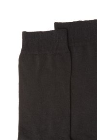 Black cotton socks with ribbed cuffs, featuring a smooth texture and a simple design, stacked side by side.