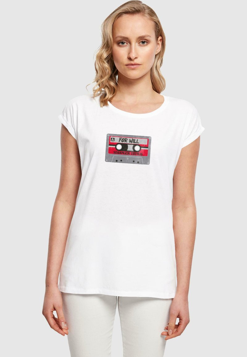 Valkoinen puuvillapaita, jossa on nauhakaappi grafiikka punaisilla yksityiskohdilla, tekstillä "FOR WILL" ja "STRANGER THINGS" -brändäys. Lyhyet hihat.