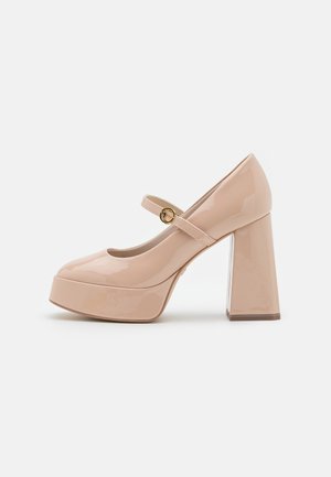 Chaussure plateforme Mary Jane en cuir verni beige avec talon bloc et bride à boucle dorée, vue de côté sur fond blanc.