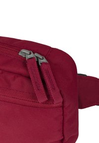 Borsa a spalla in tessuto bordeaux con chiusura a doppia cerniera, superficie testurizzata e manici piatti per un uso regolabile. Cuciture rinforzate per una maggiore durata.