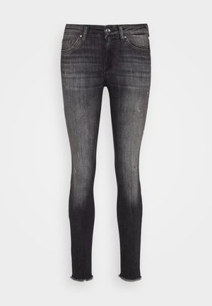 Jeans ajustados en denim gris oscuro, con un leve desgastado, cintura a media altura y dobladillos deshilachados, con una textura suave.