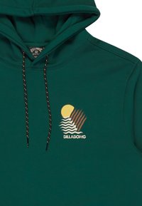 Felpa con cappuccio in tessuto verde scuro, caratterizzata da una grafica ricamata con un sole e onde. Coulisse regolabile con dettagli marroni.