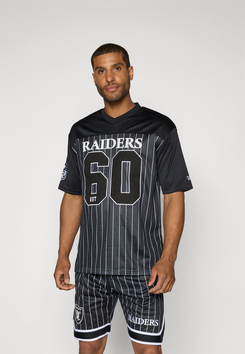 Juodas tinklinis sportinis marškinėliai su vertikaliomis baltomis juostelėmis, priekyje yra užrašai "RAIDERS" ir "60". Tai derinama su atitinkančiomis šortais, papuoštomis logotipu ir juostelėmis.