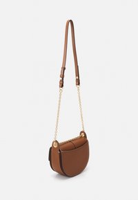 Borsa a tracolla in pelle marrone con una forma curva, dotata di una tracolla con catena dorata e dettagli cuciti lungo i bordi.