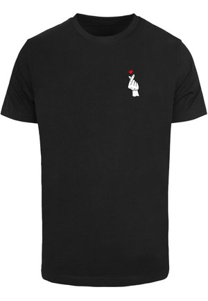 Sort T-shirt med en lille hvid hånd, der laver et fingerhjerte-gestus, og et lille rødt hjerte over fingrene på den øvre del af brystet.