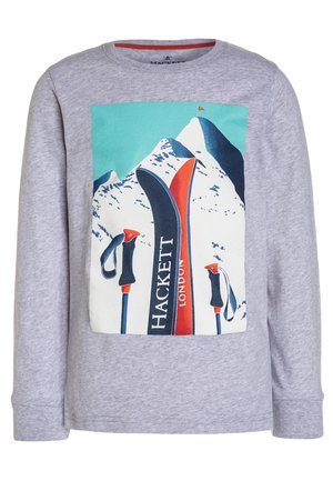 Grijs shirt met lange mouwen met een afbeelding van ski's en stokken voor een besneeuwde berg met blauwe lucht en een rood vaandel.