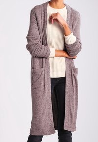 Long cardigan à l'avant ouvert en gris chiné, fabriqué en matériau tricot doux. Il dispose de deux poches avant et d'une coupe décontractée.