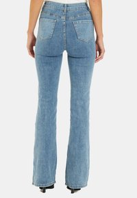 Jeans a zampa d'elefante in denim azzurro chiaro, con vita alta, due tasche posteriori e un orlo pulito in fondo. Tessuto liscio con cuciture classiche.