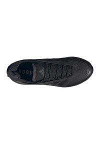 Baskets de sport noires avec une tige en mesh, lacets et la marque "BOOST" visible sur la semelle intérieure, montrées de dessus sur un fond blanc.