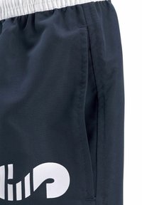 Jūras spēku sporta šorti ar baltu elastīgu jostu. Iekļauj sānu kabatas un izteiktu baltu logo uz kreisā augšstilba. Gluda auduma tekstūra.