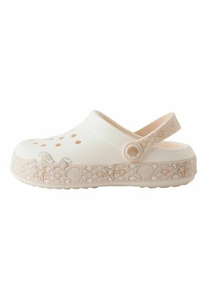 Sabot blanc à enfiler avec des trous de ventilation, une bride de talon réglable et des motifs décoratifs beiges sur le thème de la mer sur la semelle et la bride.