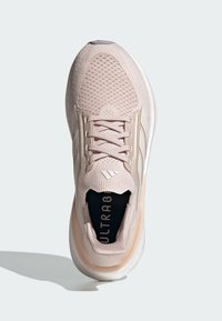 Svijetlo ružičasta tenisica za trčanje s pletenom gornjom površinom, mrežastom teksturom, toniranim vezicama i bijelim đonom. Unutra se nalazi oznaka 'ULTRABOOST'.