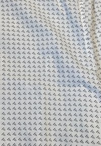 Tessuto con motivo in azzurro chiaro con piccole linee nere diagonali. Presenta un piccolo logo ricamato nella sezione inferiore. Texture liscia.