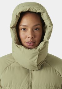 Chaqueta de plumón verde claro con capucha, cuello alto, cierre de cremallera y textura acolchada visible. Tejido suave con relleno blando.