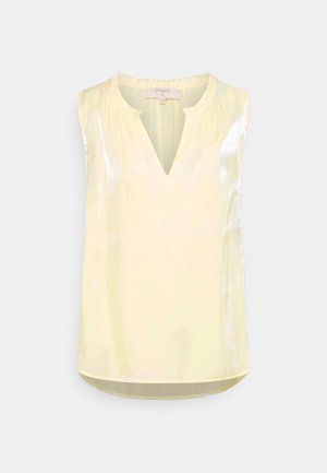 Blouse jaune pâle sans manches avec un subtil éclat, encolure ronde froncée et petite ouverture en forme de V à l’avant.