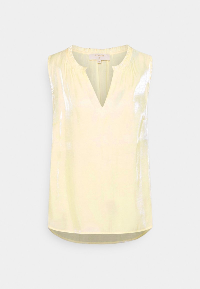Blouse jaune pâle sans manches avec un subtil éclat, encolure ronde froncée et petite ouverture en forme de V à l’avant.