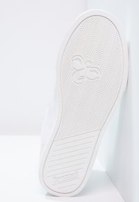 Sola de sapatilha atlética branca com um padrão de desgaste em espinha de peixe, com uma impressão de logotipo e textura lisa. Design minimalista com linhas limpas.